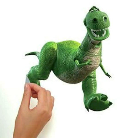 Hand placing Toy Story 3 Peel And Stick Wall Decals Set With 34 Repositionable Glow In The Dark Stickers featuring Rex on wall.