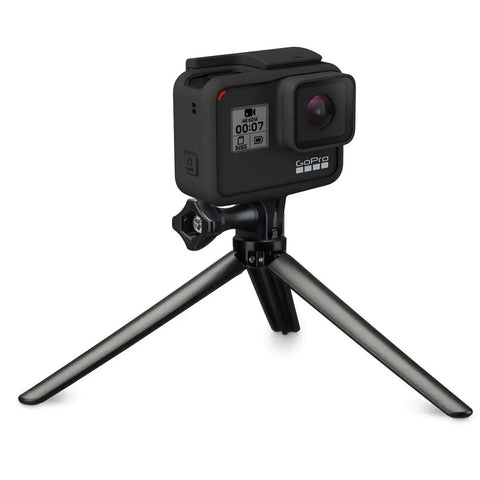 3 In 1 Do It All Action Camera Grip Arm And Tripod For All In One Stability with a camera on tripod mode on a flat surface.