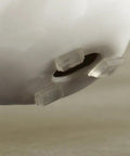Close-up of clear Half Inch Round Self-Stick Cabinet Bumper Pads For Quiet Closures And Scratch-Free Surfaces, applied to ceramic base.