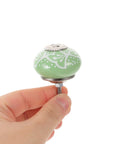 Top Shelf Vintage Floral Ceramic Cabinet Knobs And Drawer Pulls Set To Freshen Your Space With A Darn Cute 40mm Round Design, green floral knob held in hand.