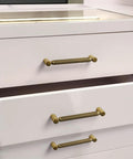 Six Pack 5 Inch Center To Center Antique Brass Cabinet Pulls With Knurled Grip And Circular End Caps on white drawers