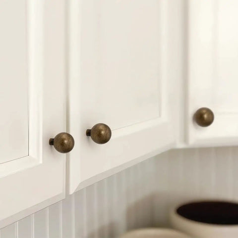 10 Pack Antique Brass Cabinet Knobs 0.9 Inch Round Solid Zinc Alloy Vintage Dresser Drawer Pulls on white cupboard