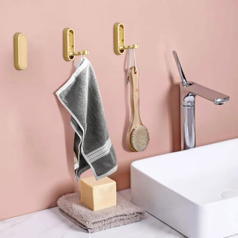 Foldable Wall Mounted Coat Hook Built With Heavy Duty Steel No Sweat Install, holding a towel and brush in a modern bathroom.