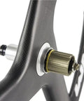 Close-up of 56Mm Carbon Road Bike Tri Spoke Wheelset hub, 23mm wide, 700C clincher, matte 3K finish, compatible for Shimano speeds