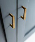 Set Of 6 Cabinet Pulls 3 Inch Center To Center Antique Brass Finish installed on dark cabinetry, showcasing minimalist style.
