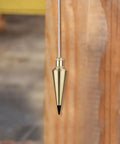 Brass Plumb Bob 0.5 Lb Weight, Gold Finish, hanging vertically for precise alignment, solid brass construction, replaceable steel tip