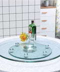 Clear Tempered Glass Lazy Susan Turntable with Silent Bearings and Six Smooth Rolling Wheels on a dining table.