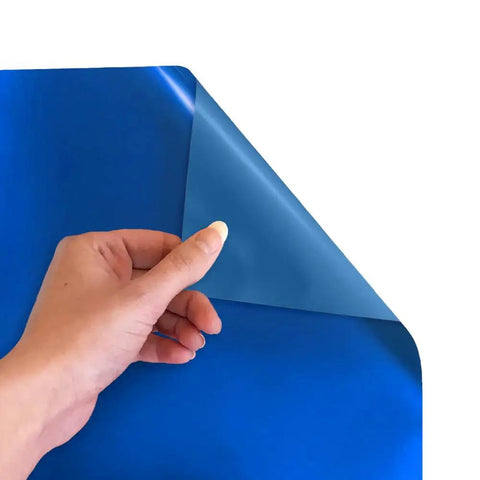 Hand holding corner of Electric Blue Siser EasyWeed Heat Transfer Vinyl Roll 11.8 Inch By 3 Feet for DIY Apparel