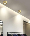 8 Pack Brass Trim Retrofit LED Recessed Lighting Tough As Nails Copper Housing Directional Eyeball Downlights Triple Switch 3000K To 6500K Clean Smooth Glow installed in modern retail setting.