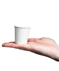 A hand holding a 3 Oz White Paper Cup from the Set Of 600 For Espresso Tea Samples And Mouthwash Small Disposable Cups for drinks.
