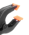 Close-up of open Heavy Duty Nylon Spring Clamp Set For DIY Woodworking, 9 Inch Clamps For Carpenter Home Workshop, with orange pads.