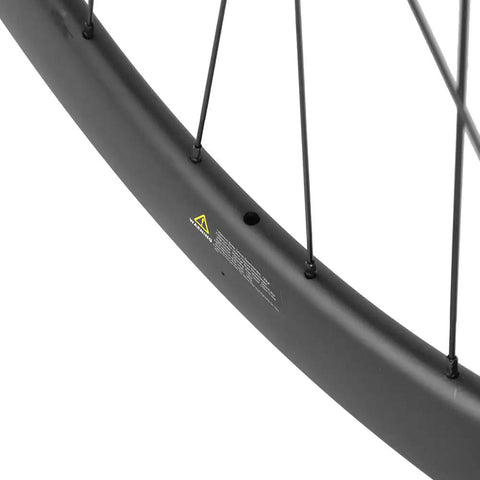 Close-up of 50mm Carbon Fiber Road Bike Wheelset Disc Brakes 700c Tubeless Ready rim, showing carbon fiber texture and spokes.