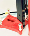 Front view of concrete core drill with red mounting base and vertical frame; bolts and power cord visible.
