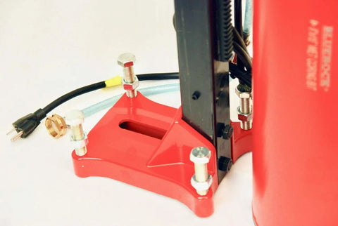 Front view of concrete core drill with red mounting base and vertical frame; bolts and power cord visible.