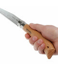 Badass Lightweight Folding Saw For Weekend Campouts And Garden Grind Cuts Branches Fast With Razor Sharp Carbon Steel Blade Secure Virobloc Lock And Natural Beechwood Handle held in hand.