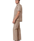Top Tier Mens Scrub Jacket With Zip Front And Legit Pen Pocket Hella Comfy Khaki Healthcare Top For Nurses And Doctors Smooth All Day Care Vibe Straight Fire Clinical Uniform For Everyday Pros, model in khaki scrub jacket and pants standing sideways.