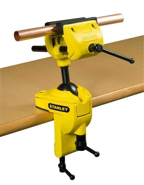 MaxSteel Multi Angle Hobby Vice With 360-Degree Ball Joint clamped to table holding copper pipe, yellow and black design