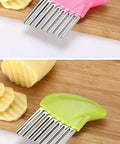 Two-piece stainless steel crinkle cutter set with pink and green handles on a wooden cutting board