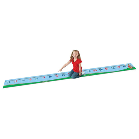 Child sitting on Hands On 0 To 30 Number Line Floor Mat For Kids 22 Foot Vinyl Math Path For Counting Addition And Subtraction Practice.