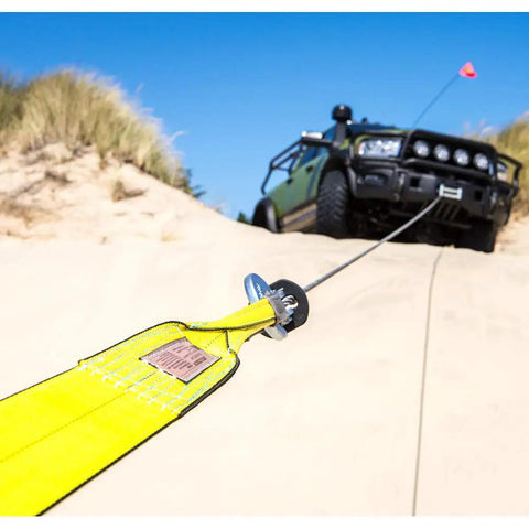 Full Size Winch Extension Strap Four Inch By Thirty Foot Polyester Webbing With Reinforced Eyelets Tough Built To Last Off Road Recovery Gear Built For Real World Use 31,360 Lbs Minimum Breaking Strength attached to off-road vehicle in desert terrain