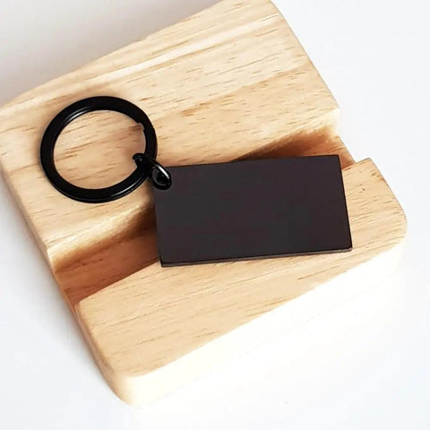 Outrigger Canoeist Lover Keychain For Paddlers Coach Gift on wood, durable stainless steel black car keychain, side view