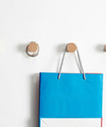 No Fuss Solid Wood Wall Hooks Holds Bags Hats And Coats Game Changer In Home Organization Multi Purpose Coat Rack And Towel Holder showing mounted hooks with a blue bag hanging.