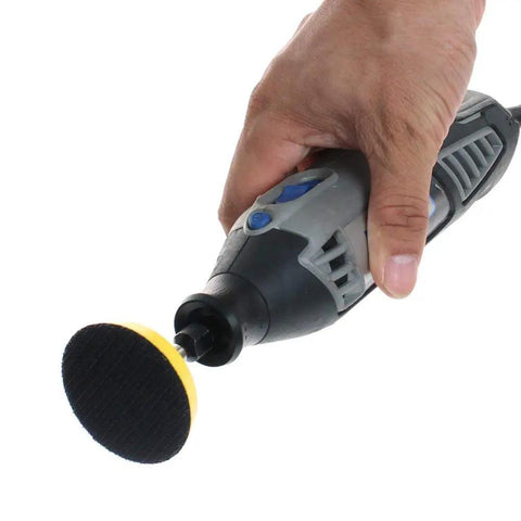 Hand holding a drill with a sanding disc from the 100 Pack 2 Inch Sanding Discs Kit With Polishing Pad Plate, Assorted Grits 40 Through 400.