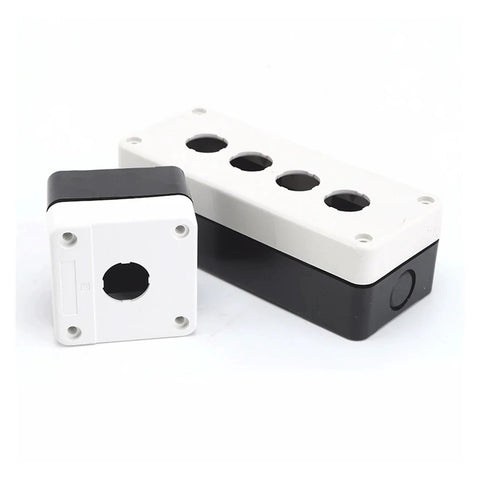 Two-piece white plastic button box with four top ports and black base; automotive electrical junction box assembly.