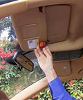 Resqme Emergency Car Escape Tool accessory pack on sun visor; orange 2-in-1 seatbelt cutter and window breaker
