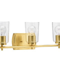Adley Collection 3 Light Clear Glass Bath Vanity Light In Satin Brass, bar fixture with three clear glass shades.
