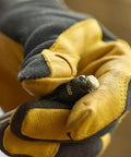 Gloved hand holding Reversible Hex Driver With 1/4 And 5/16 In Sockets, Sawtooth Sealant Cutter For Go To Fastener Removal, close-up view.