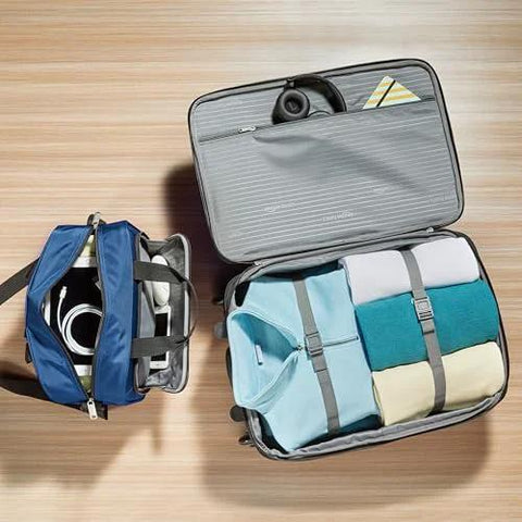 Open view of Amazon Basics navy blue luggage set: 23-inch expandable wheeled suitcase with clothes; 15-inch tote.