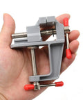 Hand holding Grab N Go Portable Table Vise Clamp for Workbench Swivel Universal Vise, lightweight compact bench tool.