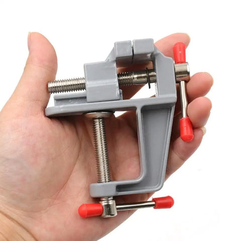 Hand holding Grab N Go Portable Table Vise Clamp for Workbench Swivel Universal Vise, lightweight compact bench tool.
