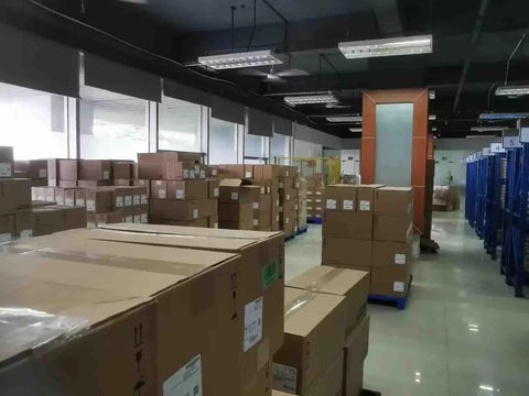Warehouse filled with sealed boxes, possibly containing 2080-LC20-20QBB Micro820 20 I O ENet IP Controller PLC for industrial use