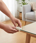 Person applying Super Slick U Shaped Baby Proofing Corner Guards For Glass Tables And Thin Furniture on a glass table edge.