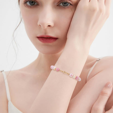 Woman wearing bracelet with 80Pcs Pro Grade Bead Tips Knot Covers 18K Gold Plated Brass Clamshell End Cap on wrist