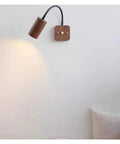 Modern Walnut Wall Sconce With 360 Degree Swivel Spotlight mounted on wall, showcasing adjustable beam for versatile lighting.
