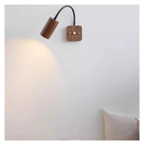 Modern Walnut Wall Sconce With 360 Degree Swivel Spotlight mounted on wall, showcasing adjustable beam for versatile lighting.