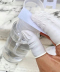 Hands wearing Latex Finger Cots 400 Count Small Disposable Fingertip Gloves holding a cotton pad near a bottle