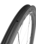 Close-up of 50/25mm UD Matte Finish Carbon Wheelset for 700c tubeless ready black road bike with V brake compatibility.
