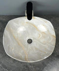 Top view of a bathroom sink marble ceramic sink with artistic design and center drain in modern hotel bathroom.