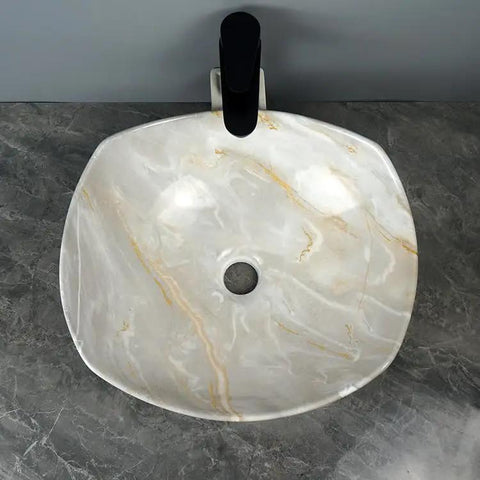 Top view of a bathroom sink marble ceramic sink with artistic design and center drain in modern hotel bathroom.