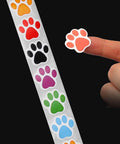 Person holding colorful paw sticker from Dog Paw Print Stickers Roll 500 Self Adhesive Paw Labels Colorful Animal Shape Wall Decals