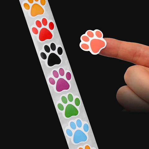 Person holding colorful paw sticker from Dog Paw Print Stickers Roll 500 Self Adhesive Paw Labels Colorful Animal Shape Wall Decals
