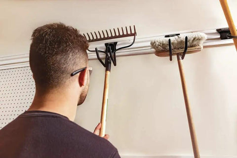 Person organizing tools on VersaTrack Garage Storage Rail With Twenty Piece Mounting Accessories For Drywall Studs And Masonry Pegboard