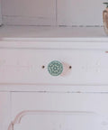 Six Old School Vintage Ceramic Drawer Pulls Set, Antique Single Hole Cabinet Knobs For Dressers, Cupboards, And Wardrobes In Celadon Blue installed on a white drawer
