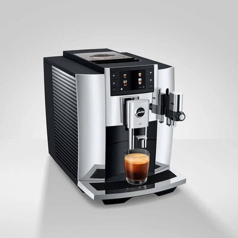 Level Up Your Daily Grind With This Sleek Chrome Automatic Coffee Machine Boasting One Touch Operation Built In Grinder And Rich Foam Frother For A Real Deal Barista Experience Certified Refurbished, front angle with coffee glass.