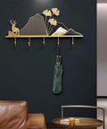 Tough Metal Wall Hook Heavy Duty Coat Rack With Extra Spacious Storage For Keys Umbrellas Coats And Hats on a black wall featuring a decorative nature design.