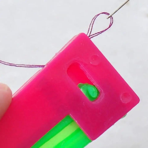 Close-up of pink and green needle threader from 3Pcs Automatic Needle Threader Set For Hand Sewing Easy No Fuss Threading Device For Small Eye Needles Ideal For DIY Embroidery Cross Stitch Craft Projects Elderly Friendly Tailors And Hobbyists